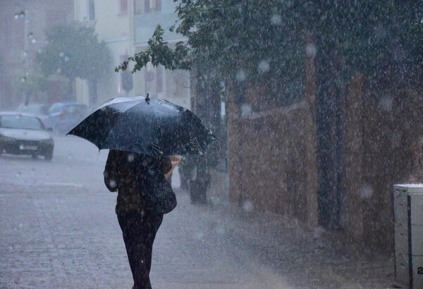 Άνθρωπος με μαύρη ομπρέλα στα χέρια εν μέσω καταιγίδας