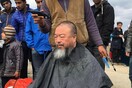 Ο Ai WeiWei κουρεύεται στο υπαίθριο μπαρμπέρικο των προσφύγων της Ειδομένης