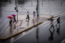 Κόσμος περπατά μέσα στη βροχή με ομπρέλες