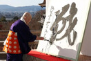 Βουδιστής μοναχός ζωγραφίζει το σύμβολο του πολέμου