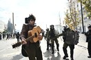 Πορεία για τα Τέμπη στην Αθήνα: Μουσικός με την κιθάρα του δίπλα από τα ΜΑΤ την ώρα των επεισοδίων