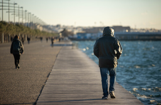 Άντρας με μπουφάν περπατά στην παραλία Θεσσαλονίκης