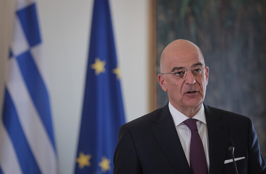 Ο Νίκος Δένδιας μπροστά από σημαίες