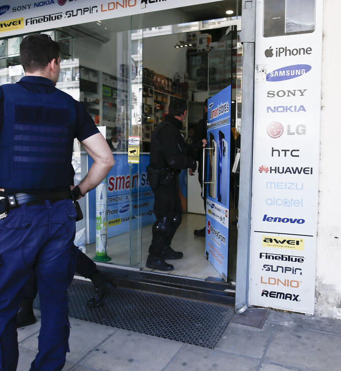 Αστυνομικός μπροστά σε κατάστημα