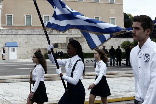 Η σημαιοφόρος με τη μαντήλα και μια μαθήτρια από το Αφγανιστάν