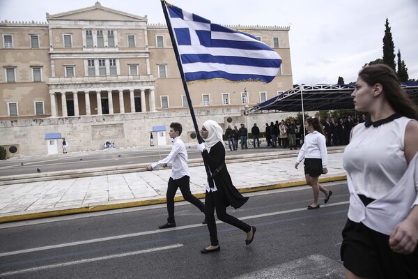 Η σημαιοφόρος με τη μαντήλα και μια μαθήτρια από το Αφγανιστάν