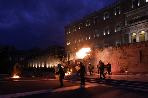 Μέσα ψηφίζουν Μνημόνιο και έξω καίνε- Φωτογραφίες από τα επεισόδια στο Σύνταγμα