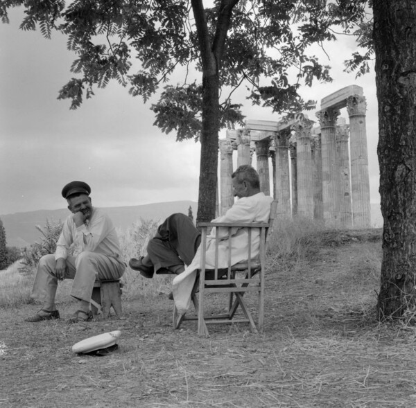 Greece, men sitting near Temple of Olympian Zeus ruins