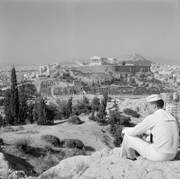 Greece, sailor sitting on hill overlooking Athens and Acropolis