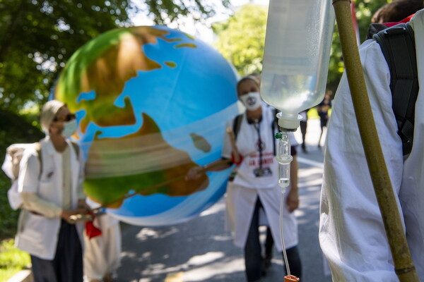 Γιατροί διαδήλωσαν μπροστά στο κτίριο του ΠΟΥ: «Δεν υπάρχει εμβόλιο κατά της κλιματικής αλλαγής»