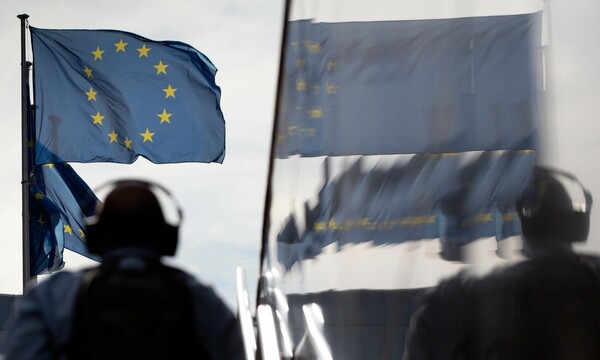 Ανδρας με ακουστικά μπροστά από την σημαία της ΕΕ
