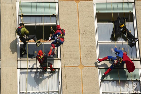 Acrobatic superheroes scale children's hospital to visit young patients