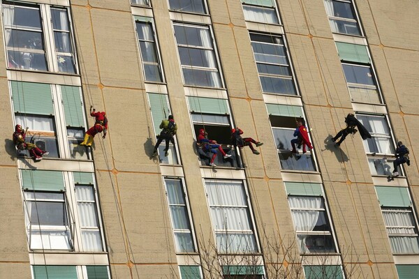 Acrobatic superheroes scale children's hospital to visit young patients