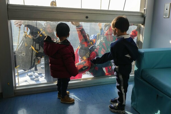 Acrobatic superheroes scale children's hospital to visit young patients