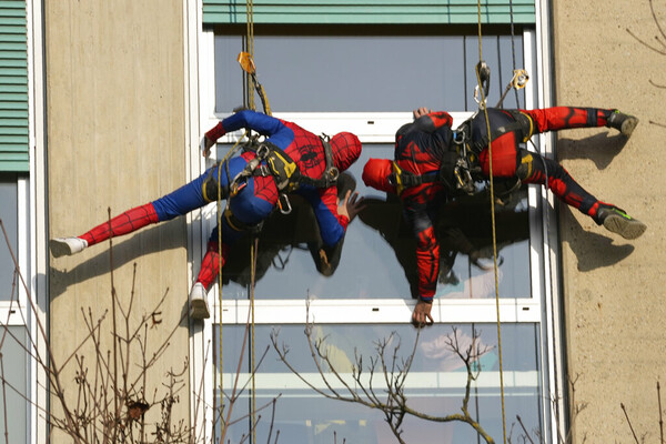 Acrobatic superheroes scale children's hospital to visit young patients