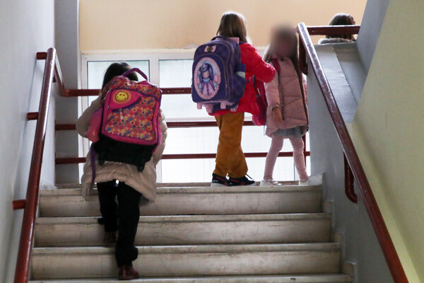 Παιδιά με σχολικές τσάντες ανεβαίνουν σκαλιά