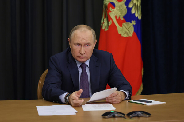 Ο Βλαντίμιρ Πούτιν καθιστός σε τραπέζι