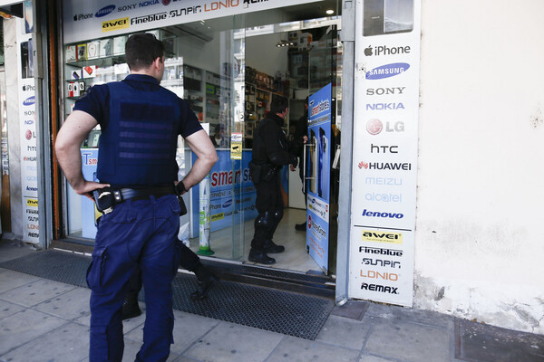Αστυνομικός μπροστά σε κατάστημα