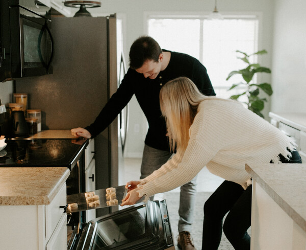 Άνδρας και γυναίκα βάζουν ταψί στον φούρνο