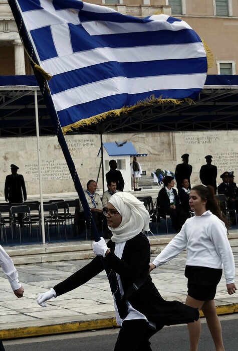 Η σημαιοφόρος με τη μαντήλα και μια μαθήτρια από το Αφγανιστάν