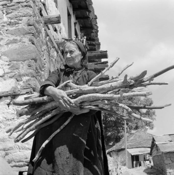 Γυναίκα κουβαλά στα χέρια ξύλα.