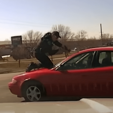 Iowa: Police officer clings to roof of car as suspect tries to escape