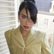 Η Dua Lipa με κίτρινη ζακέτα