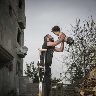 H φωτογραφία της χρονιάς: Η συγκλονιστική στιγμή πατέρα και γιου με φόντο τον πόλεμο στη Συρία