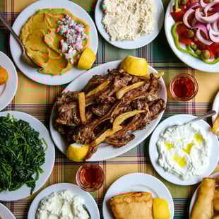 Αυλή στρωμένη με χαλίκι και πιατέλες με παϊδάκια στον Κορομηλά