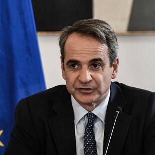 Ο Κυριάκος Μητσοτάκης μπροστά από σημαία